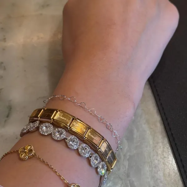 A welded chain next to a tennis bracelet and a charm